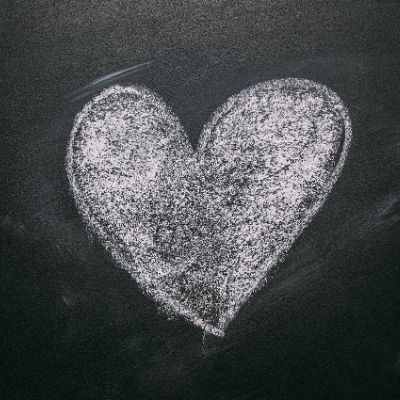 Solid heart drawn in white chalk on black chalkboard