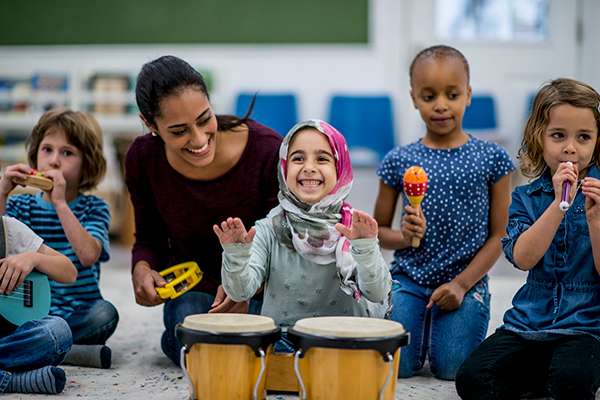 Classroom of students from diverse backgrounds playing musical instruments