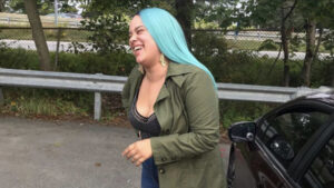 Black femme with light skin and long blue hair smiling and laughing